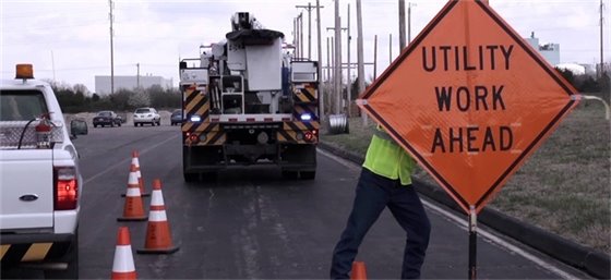 Road crews with utility work sign